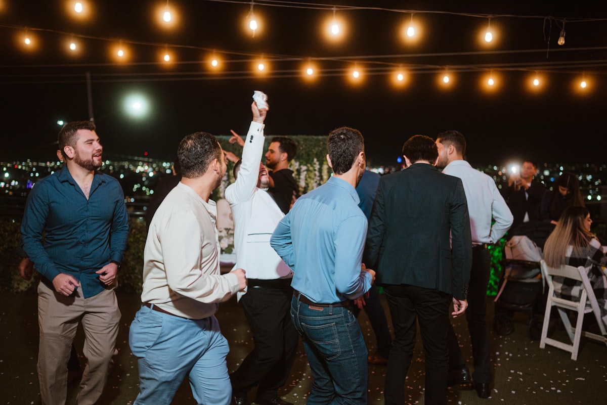 Evening dancing under bistro string lights at an outdoor Bigfork wedding