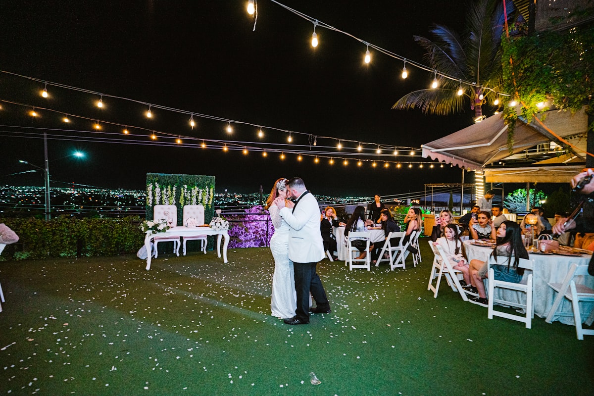 Guests dancing under string lights at an outdoor Bozeman Montana wedding reception at night