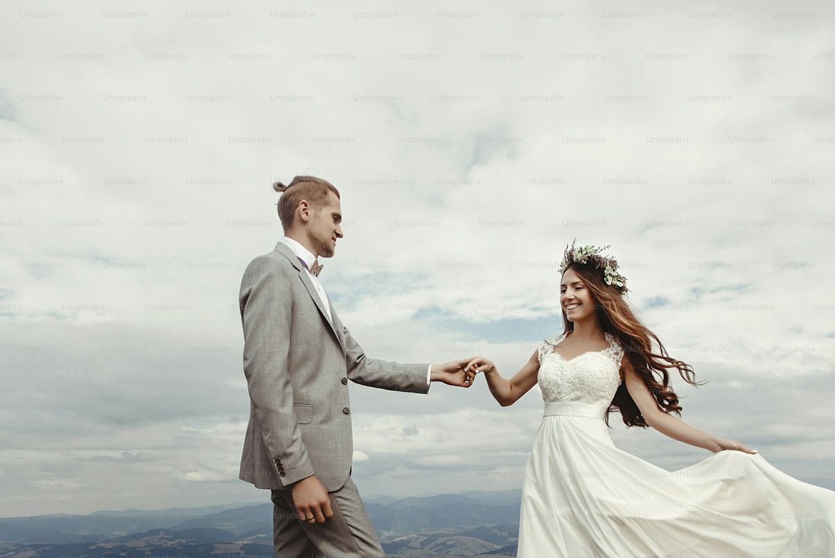 gorgeous bride and groom holding hands and dancing at sky and clouds, moment of true happiness, luxu
