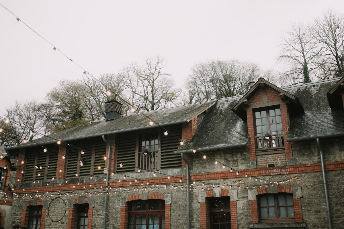 Stone building with string lights and bare trees