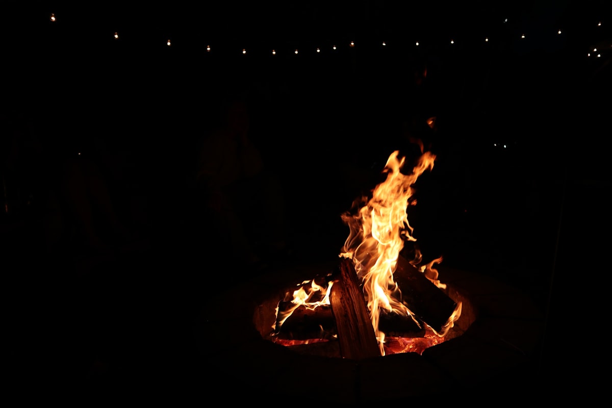 Bonfire glowing against the dark during a rustic Glacier Country Montana wedding evening celebration