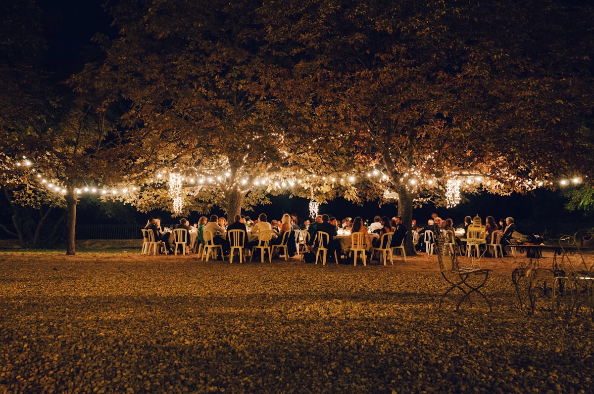 Long tables set for ranch-style rehearsal dinner under string lights in Montana