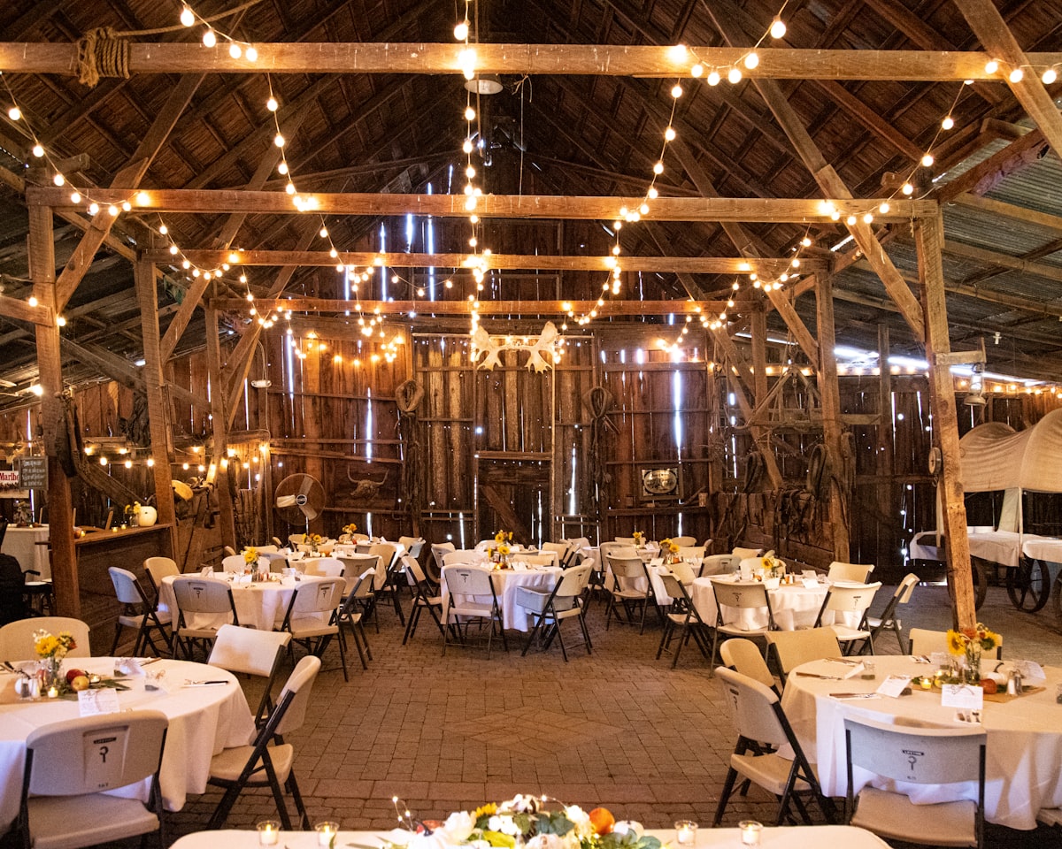 Barn wedding reception with exposed beams and lighting in Montana