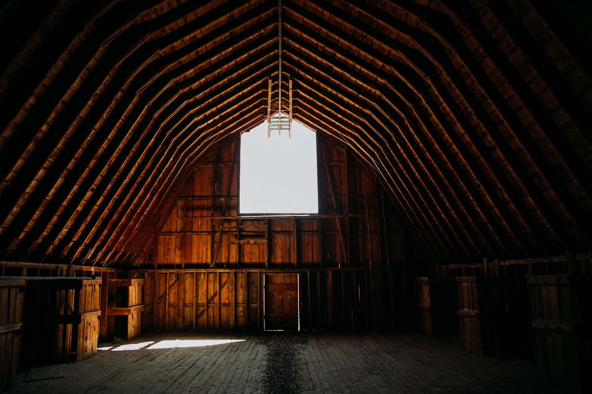 Warm light filling the timber A-frame interior of a rustic Montana barn wedding venue