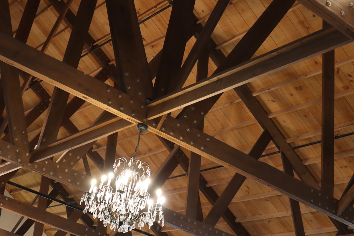 Rustic wedding venue with warm amber uplighting highlighting wooden beams
