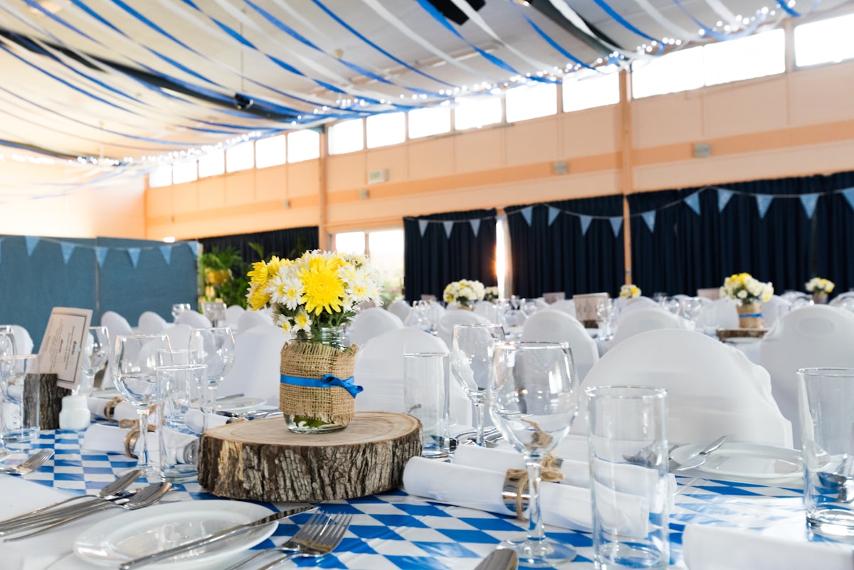 Interior of a Montana timber-frame barn set up for a wedding reception with long wooden tables