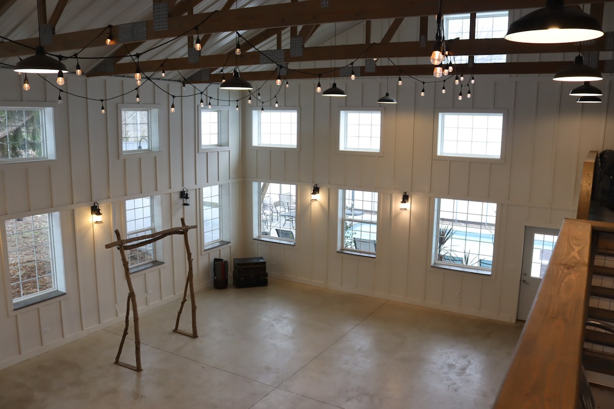 String lights and a wooden ceremony arch inside a timber-frame barn venue near Whitefish