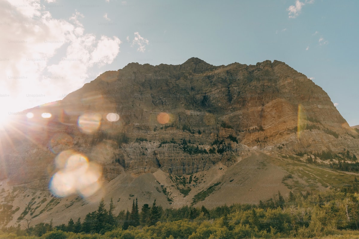 the sun shines brightly on a mountain side