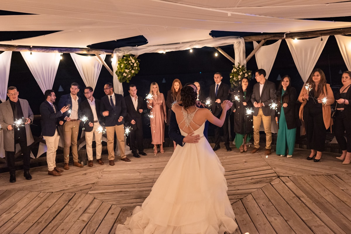 Wedding couple dancing surrounded by guests holding sparklers